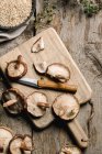 Haufen frischer brauner Pilze auf rustikalem Holztisch — Stockfoto