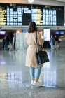 Вид сзади Женщина, стоящая в аэропорту — стоковое фото