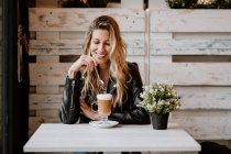 Longo cabelos na moda bela mulher loira bebendo de um copo de delicioso café espumoso com olhos fechados — Fotografia de Stock