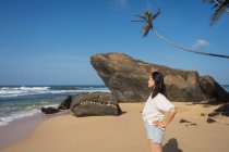 Donna in beachwear che cammina sulla sabbia a piedi nudi — Foto stock