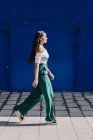 Junge glückliche trendige Frau läuft in der Stadt gegen blaue Tür — Stockfoto