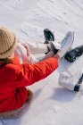 Жінка сидить на снігу і змінює чоботи — стокове фото