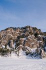 Paisaje escénico de valle nevado y majestuosas rocas cubiertas de nieve y abetos en el soleado día de invierno con cielo azul en Siberia Rusia - foto de stock