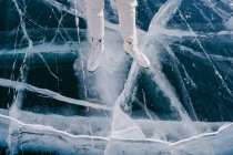 Abgeschnittenes Bild einer Frau, die auf zugefrorenem Fluss Schlittschuh läuft — Stockfoto