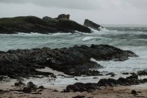 Cenário de pequena ilha perto da costa da Escócia em tempestuoso dia com colinas enevoadas e falésias — Fotografia de Stock