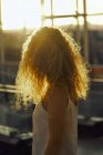 Curly charmante femme marchant dans la chambre vitrée lumière de l'aéroport au Texas — Photo de stock
