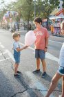 Alegre niños disfrutando dulce candyfloss en la calle - foto de stock