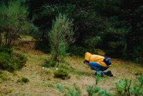 Жінка в жовтому плащі фотографує гриби — стокове фото