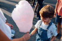Cheerful boy taking candyfloss from vendor — Stock Photo