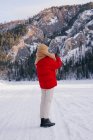 Mulher tirando fotos de montanhas nevadas com smartphone — Fotografia de Stock