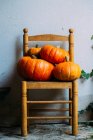 Shiny orange pumpkins composed on chairs — Stock Photo