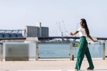 Giovane bella donna che cammina ballando sulla strada della città alla luce del giorno — Foto stock