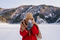 Mulher tirando fotos de montanhas nevadas com smartphone — Fotografia de Stock