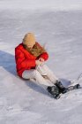Женщина сидит на снегу и меняет сапоги — стоковое фото