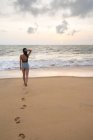 Mulher de roupa de praia andando na areia descalça — Fotografia de Stock