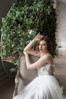 Splendida donna con labbra rosse in abito bianco seduta sulla poltrona — Foto stock