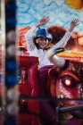 Fröhliches Mädchen reitet mechanischen Bullen — Stockfoto