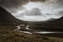 Vale do outono coberto com manchas de água após a chuva cercada por colinas nebulosas na Escócia — Fotografia de Stock