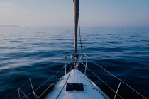 Blick vom Deck des Segelbootes, das in der Abenddämmerung auf dem ruhigen Wasser des Meeres fließt — Stockfoto
