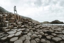 Женщина, стоящая на скале и размышляющая — стоковое фото