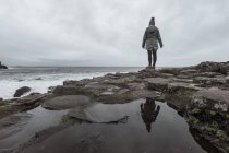 Женщина, стоящая на скале и размышляющая — стоковое фото