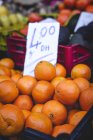 Stand full of ripe organic oranges with price tag at farmers outdoor market — Stock Photo