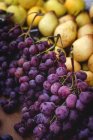 Stand lleno de uvas orgánicas maduras y peras en el mercado de agricultores al aire libre - foto de stock