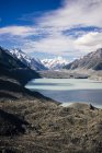 Costa rochosa do lago com céu azul e montanha Cook na Nova Zelândia — Fotografia de Stock