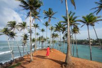 Tranquille voyageuse parmi les palmiers au bord de la mer — Photo de stock