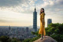 Young resting lady delighting in views in rock at big city — Stock Photo