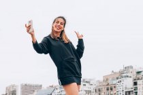 Conteúdo jovem mulher em uso casual tirando selfie na rua da cidade — Fotografia de Stock