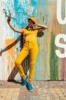 Elegante millenario scattare selfie con smartphone mentre in piedi contro il muro con gocce di vernice colorata — Foto stock