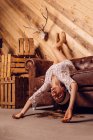 Young woman posing on a sofa upside down on wooden background — Stock Photo