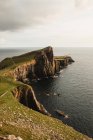 Costa rochosa entre a água tranquila do oceano durante o dia ensolarado na Escócia — Fotografia de Stock