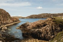 Bellissimo paesaggio panoramico di baia rocciosa con persona sola in piedi sulle scogliere in Scozia — Foto stock