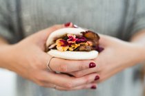 Desde arriba de las manos de la mujer sosteniendo tradicional sándwich de bollo al vapor asiático con carne y verduras - foto de stock