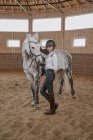 Cavallerizza in piedi con cavallo grigio ananas in arena rotonda — Foto stock
