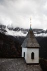 Мала церква на скелі біля лісу та гір — стокове фото