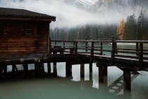 House on stilts on lake near mountains — Stock Photo