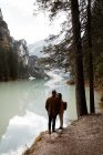 Пара відпочиває насолоджуючись видом на озеро і гори — стокове фото