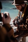 Turistas con cámaras de fotos sentados en la valla - foto de stock