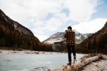 Mann genießt Aussicht in der Nähe von See und Bergen — Stockfoto