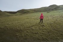 Donna anonima godendo incredibile paesaggio panoramico dell'Irlanda del Nord durante il viaggio mentre si cammina su un terreno roccioso — Foto stock