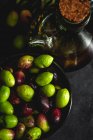 Huile d'olive extra vierge espagnole fraîche avec olives et vieille branche d'olive sur fond sombre Alimentation saine Régime méditerranéen. Végétalien. Végétarien — Photo de stock