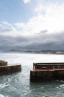 Quebra-mar rochoso com mar furioso em tempo nublado — Fotografia de Stock