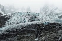 Velhas montanhas rochosas pedregosas cobertas de neve em misteriosa névoa no Chile — Fotografia de Stock