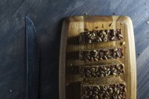 Pane integrale affettato con semi su tagliere di legno — Foto stock