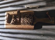 Pan integral en rodajas sobre tabla de cortar de madera sobre mesa con sombra - foto de stock