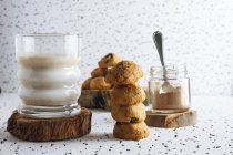 Склад органічного домашнього печива з баночкою какао-порошку та склянкою смачного молока — стокове фото