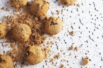 Свіже коричневе печиво з шоколадними крихтами, що розливаються безладно на білому столі — стокове фото